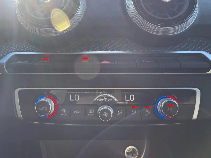 Détail de la console de climatisation de l'Audi Q2 35 TDI S line 2025 avec réglages numériques et boutons rétroéclairés.