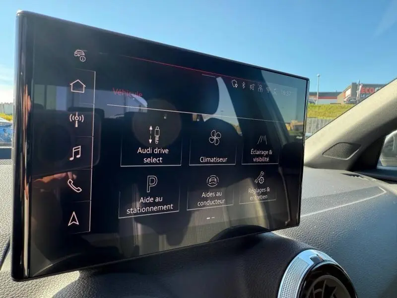 Écran tactile central de l'Audi Q2 35 TDI S line 2025 affichant les options de conduite et assistance, vue intérieure côté droit.