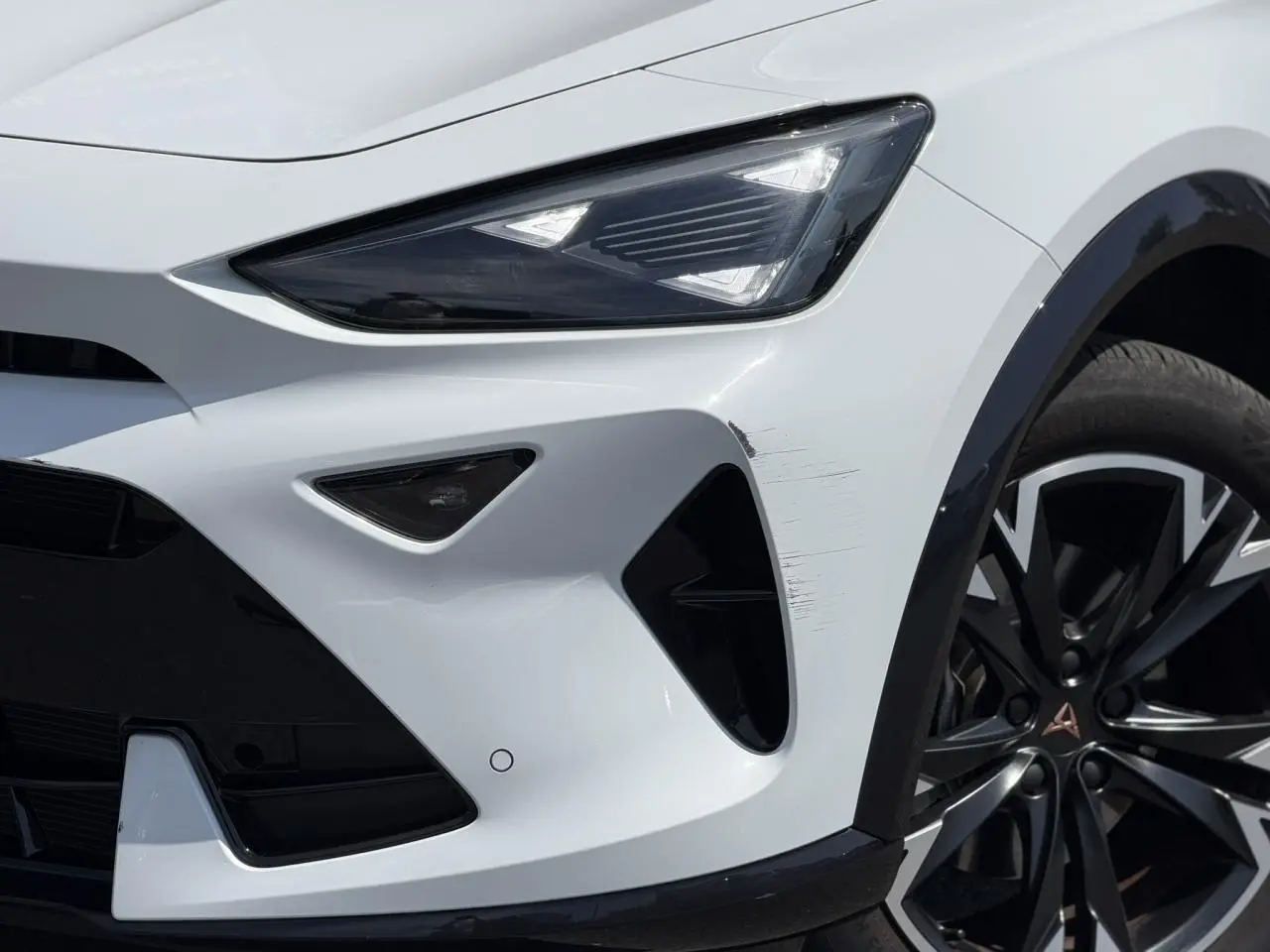 Gros plan sur l'avant droit blanc neige du CUPRA Formentor 2025 avec projecteur Tri-LED et jante alliage noire.