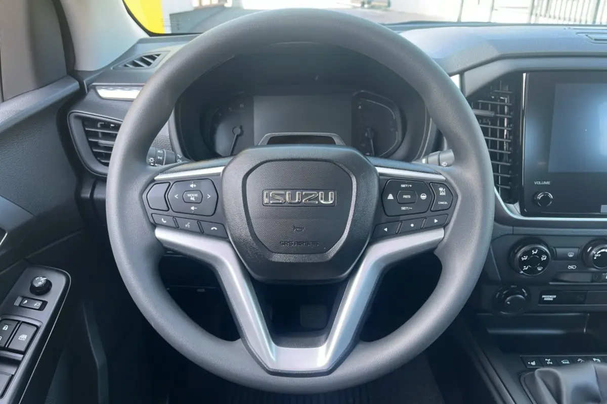 Vue frontale du volant multifonctions noir de l'Isuzu D-MAX 2026 avec tableau de bord et écran tactile.