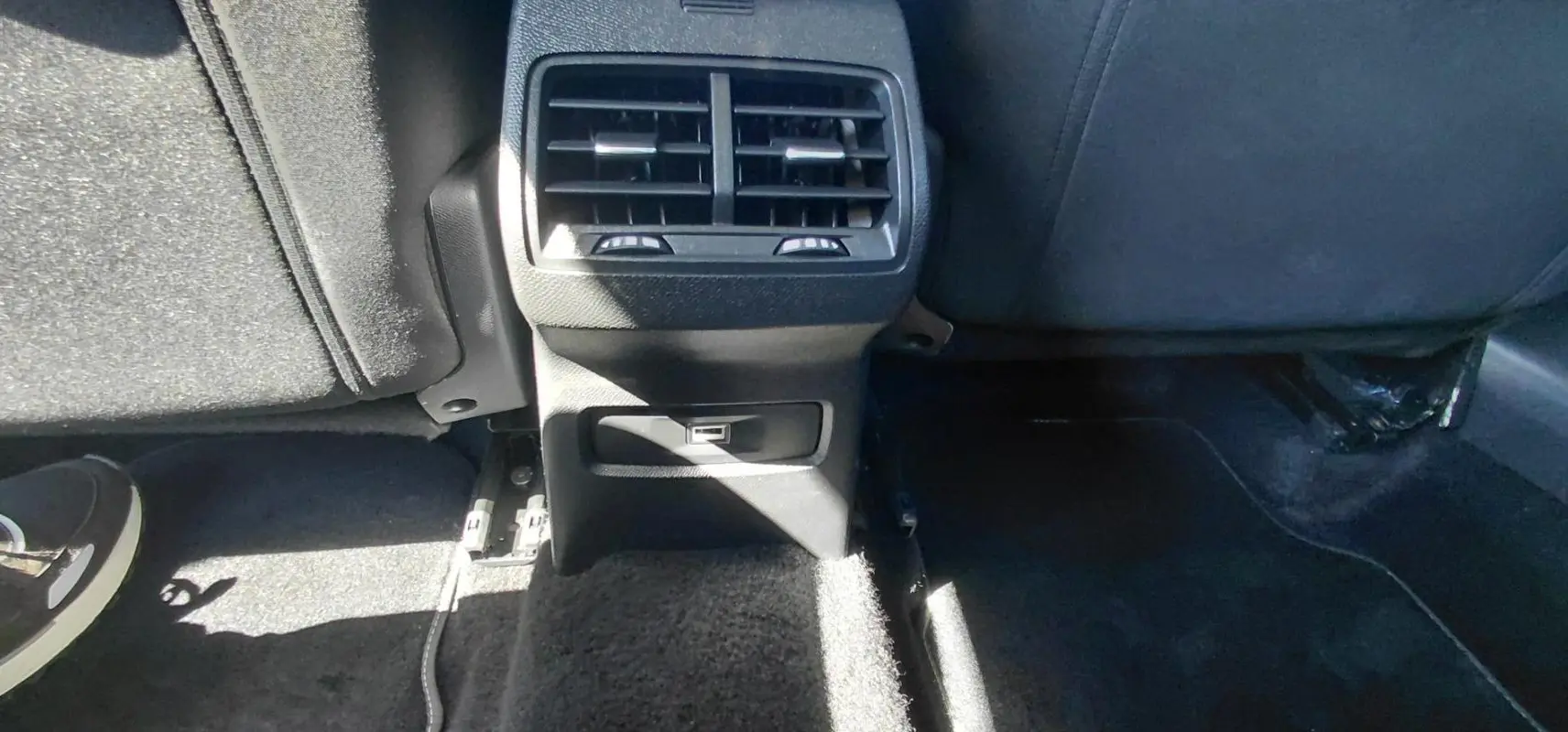 Vue rapprochée de la console arrière noire du Citroën C4 X 2025 avec bouches d’aération et prise USB.