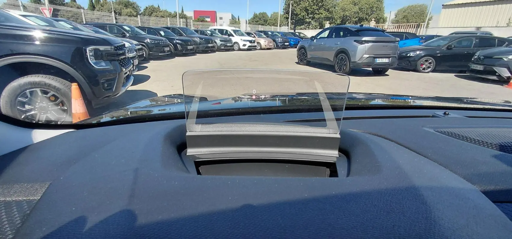 Affichage tête haute transparent sur le tableau de bord d'une Citroën C4 X noire, vue intérieure avant.