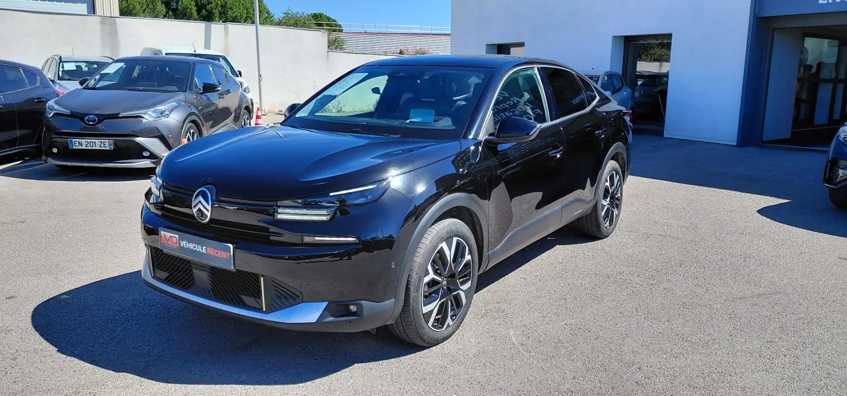 Vue 3/4 avant droite d'une Citroën C4 X noire 2025 avec jantes alliage 17 pouces et toit ouvrant panoramique.