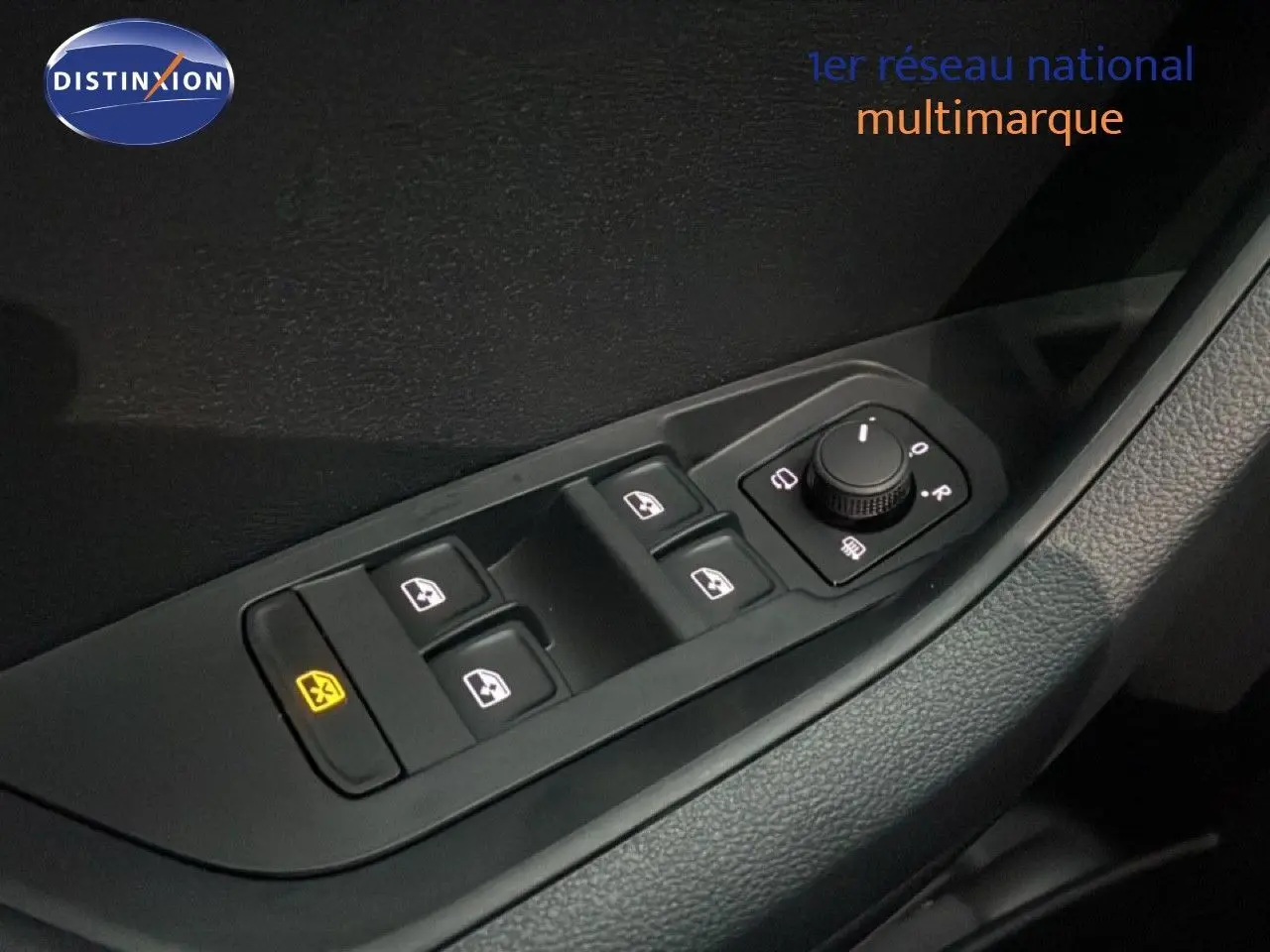 Gros plan sur les commandes des vitres électriques et rétroviseurs côté conducteur d’un Skoda Karoq gris argent 2025.