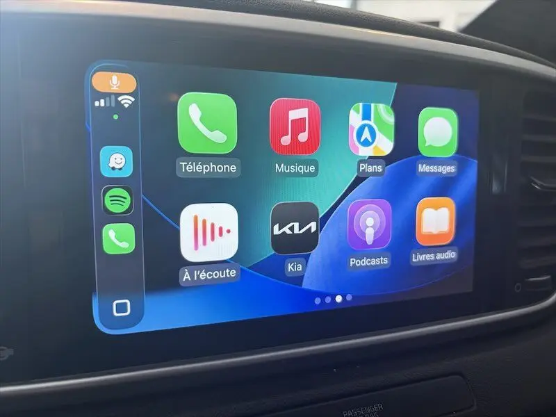 Écran tactile intérieur du Kia Sportage 2021 montrant l'interface Apple CarPlay avec plusieurs applications colorées.