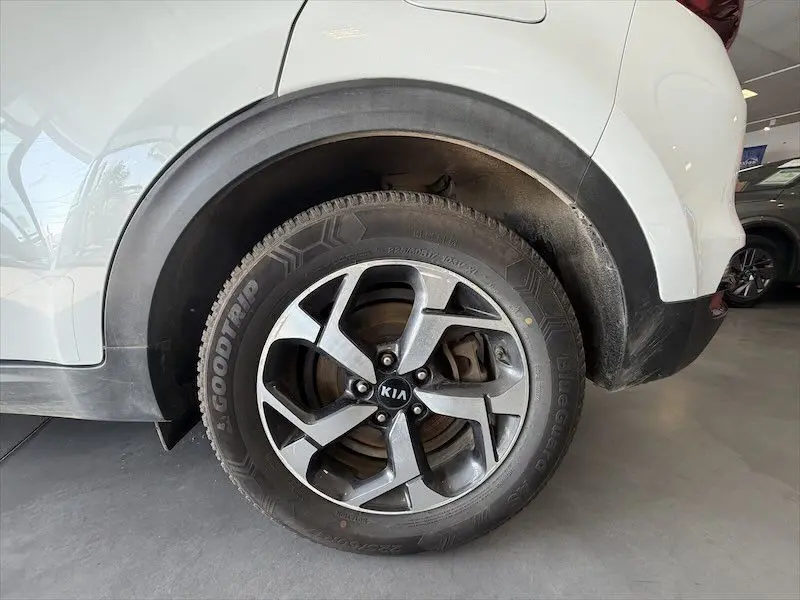Gros plan sur la roue arrière droite d’un KIA SPORTAGE blanc 2021, avec jante alliage et pneu Goodtrip visible.