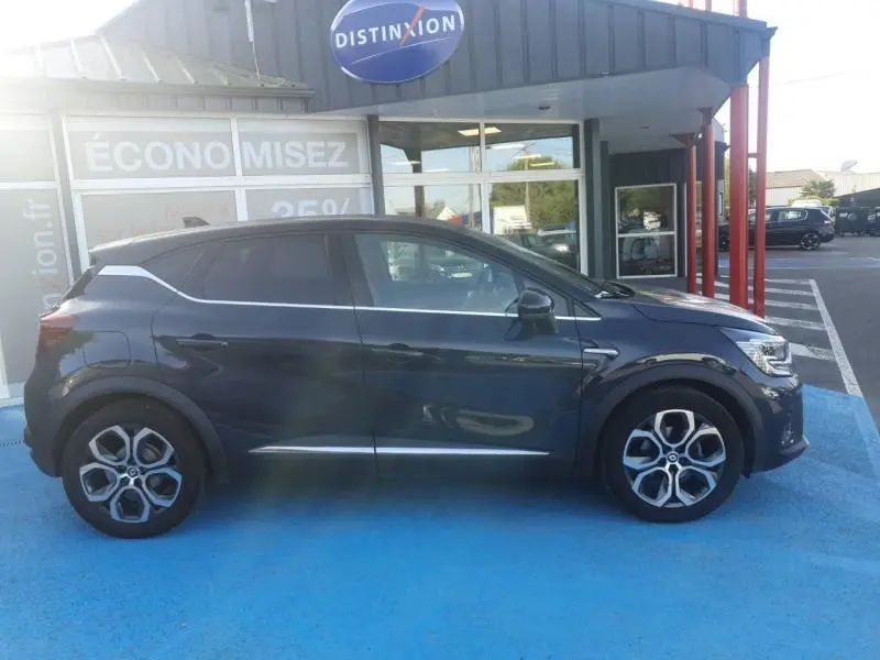 Profil droit du Renault Captur 1.3 TCe mild hybrid 140ch Techno bleu marine fumé avec toit noir étoile, roues alu.