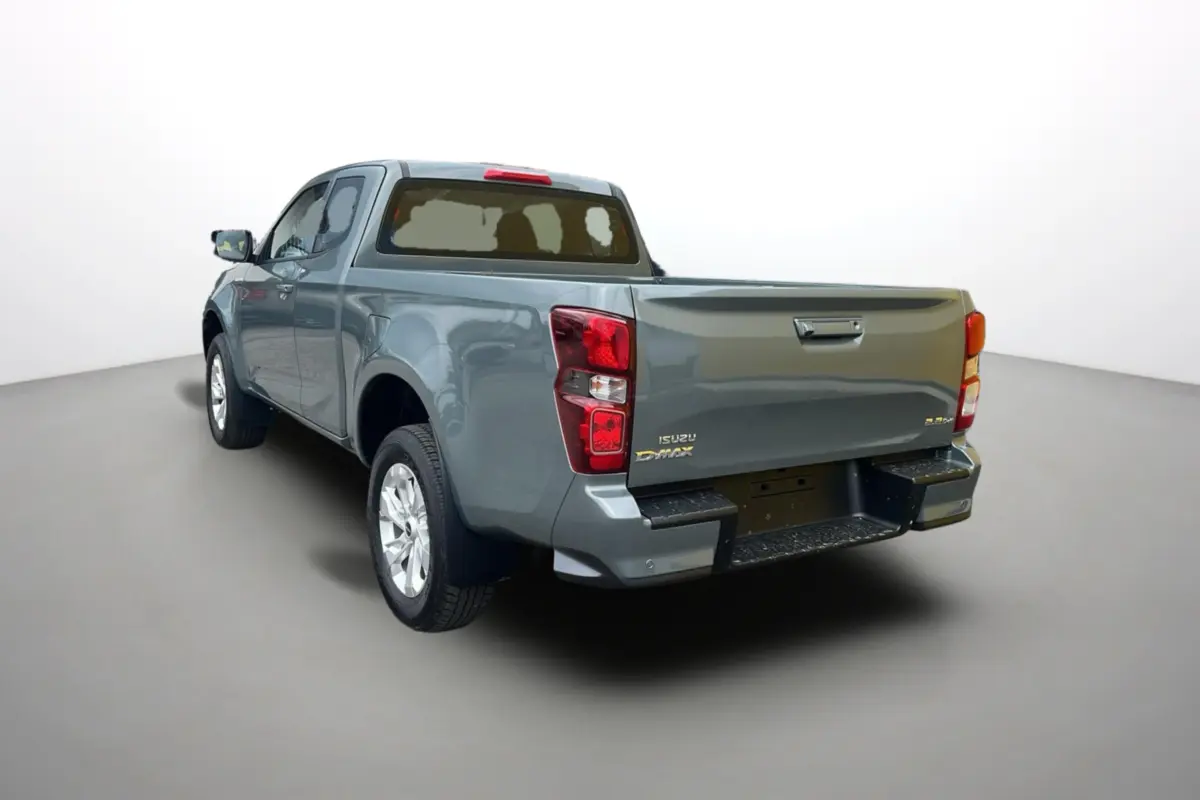 Vue 3/4 arrière du pick-up Isuzu D-MAX 2.2 TD 164 Space Evolution en vert Inishmore métallisé, jantes alu visibles.