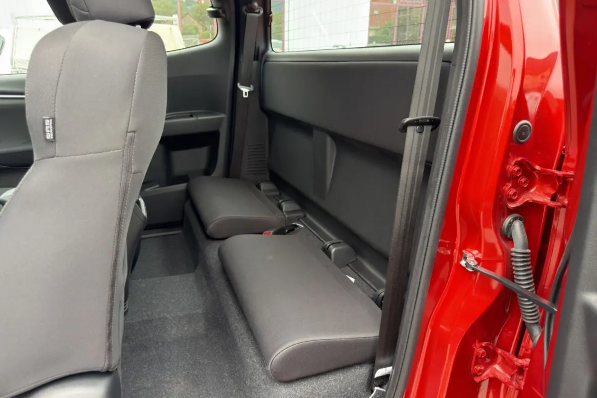 Vue intérieure côté droit des sièges arrière strapontins du pick-up Isuzu D-MAX 2.2 TD 164 Space Evolution orange Namibu.