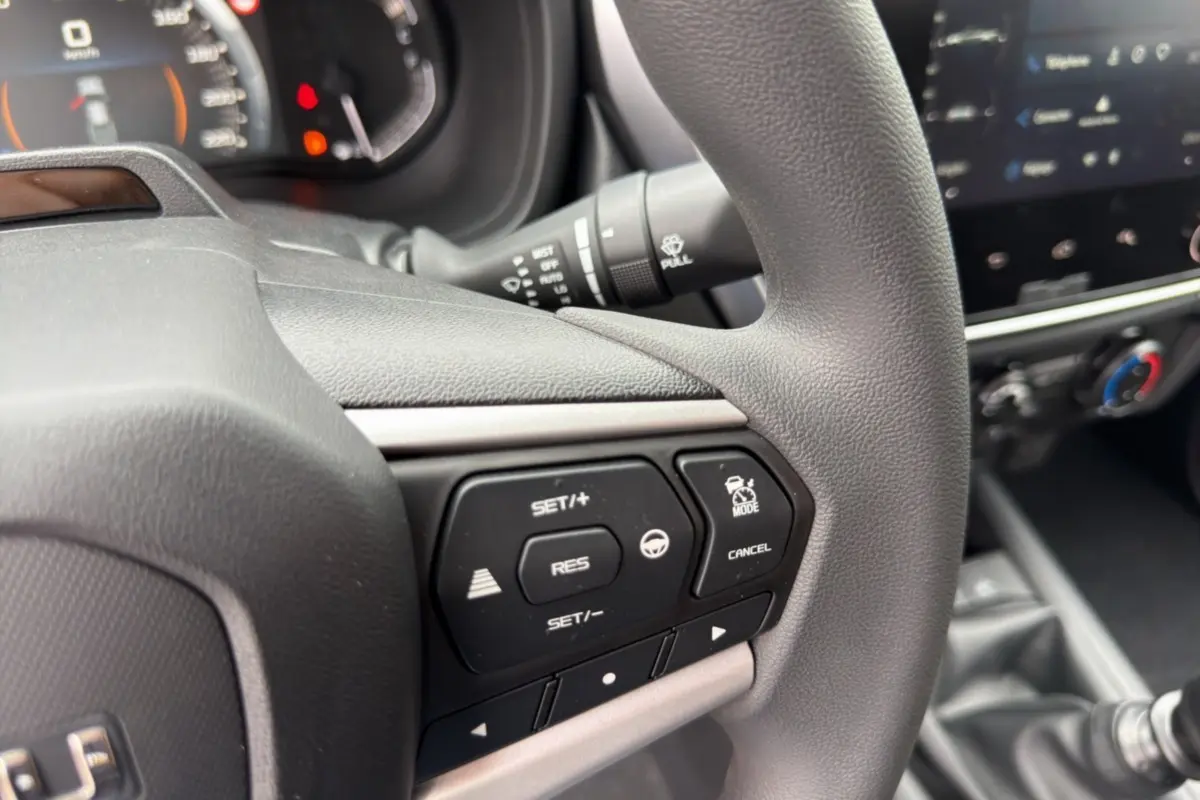 Gros plan sur le volant multifonctions noir de l'Isuzu D-MAX 2026 avec commandes de régulateur de vitesse.