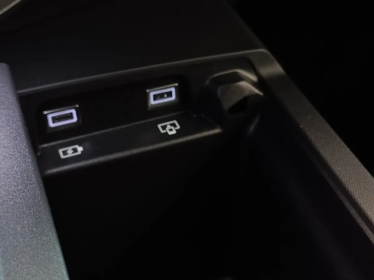 Gros plan sur deux ports USB et une prise 12V dans l'habitacle du Peugeot 5008 gris clair hybride rechargeable.