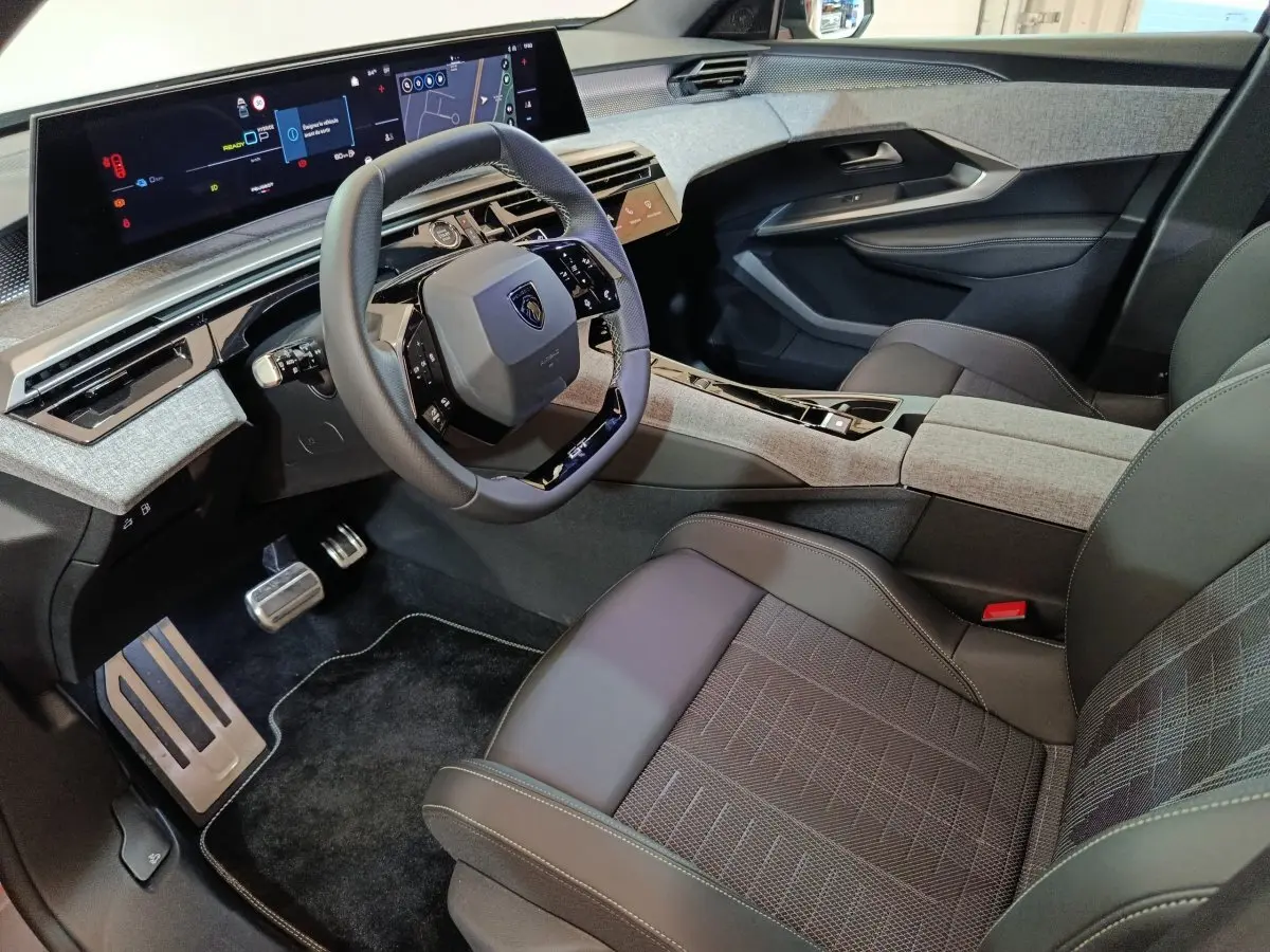 Vue intérieure côté conducteur du Peugeot 5008 1.6 PHEV 195 E-DCS7 GT 2026 avec tableau de bord numérique et volant cuir.