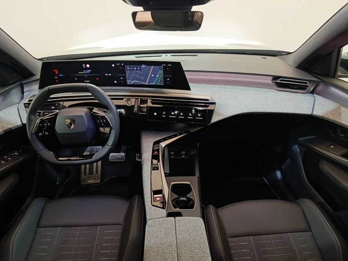 Vue intérieure avant du Peugeot 5008 1.6 PHEV gris clair, avec tableau de bord numérique et volant multifonctions cuir.