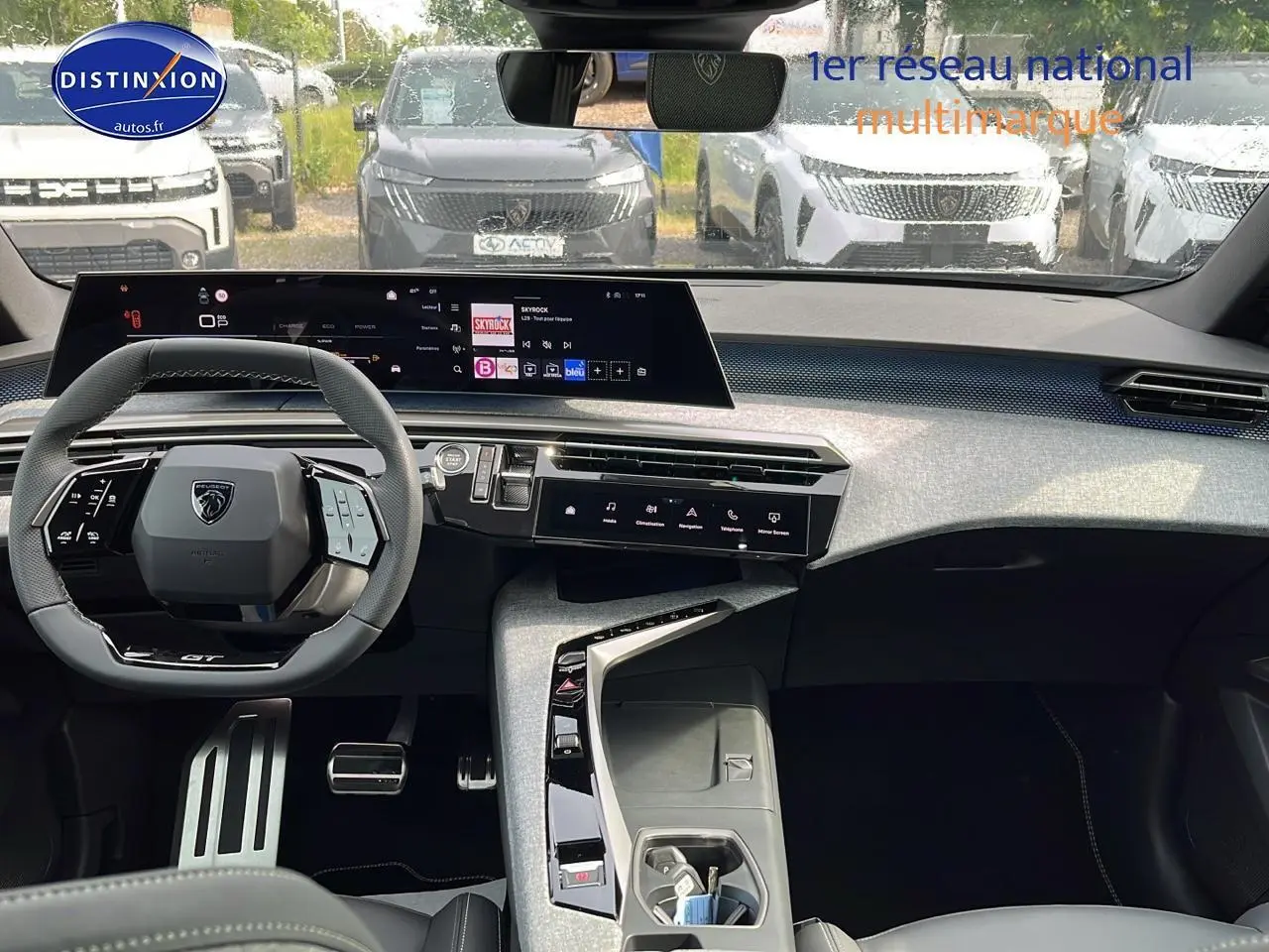Vue intérieure avant du Peugeot 3008 gris 2025, avec tableau de bord numérique et volant multifonction compact.