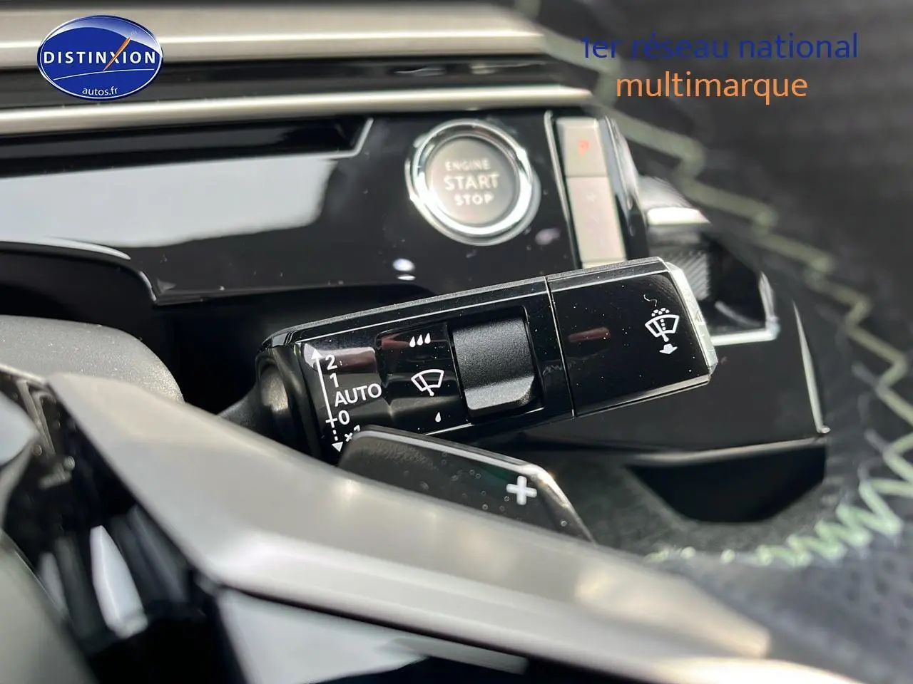 Détail intérieur du Peugeot 3008 gris 2025 montrant la commande des essuie-glaces et le bouton start/stop.