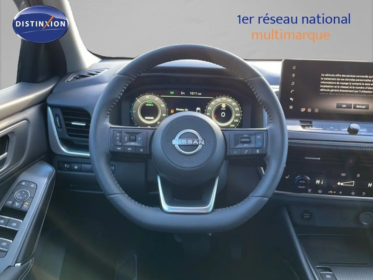 Vue intérieure centrée sur le volant du Nissan Qashqai 1.5 E-POWER gris argile, avec tableau de bord numérique et écran tactile.