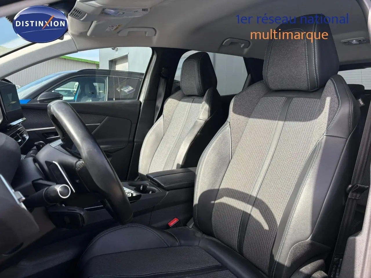 Vue intérieure côté conducteur du Peugeot 3008 hybride 2022, sièges en tissu et cuir noir avec surpiqûres grises.