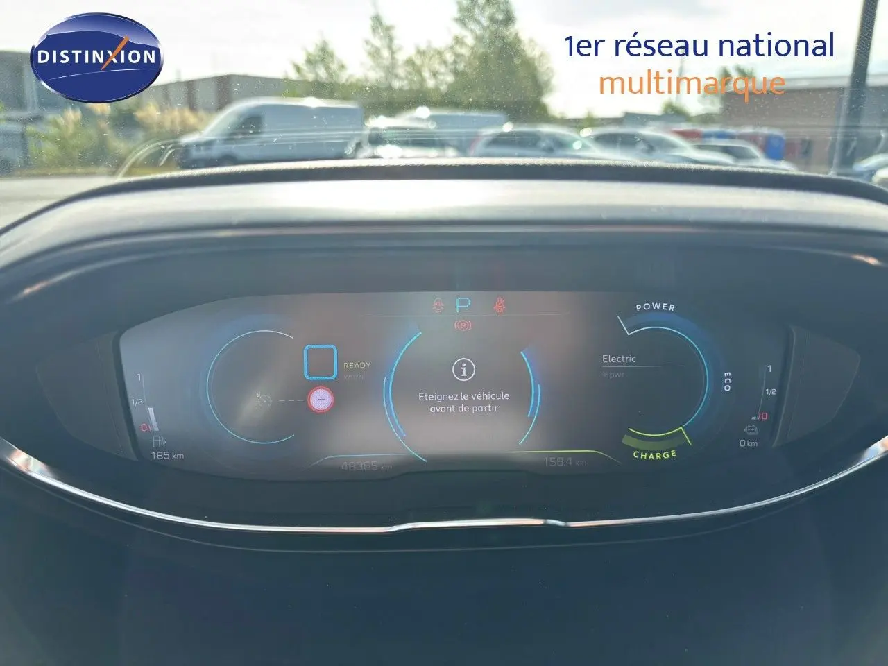 Vue rapprochée du tableau de bord numérique du Peugeot 3008 hybride gris platinium, affichant les indicateurs de charge et autonomie.