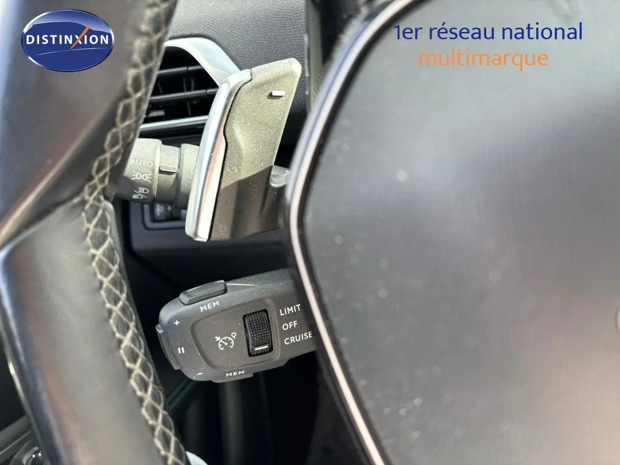Gros plan sur la commande de régulateur de vitesse au volant cuir du Peugeot 3008 gris platinium 2022.