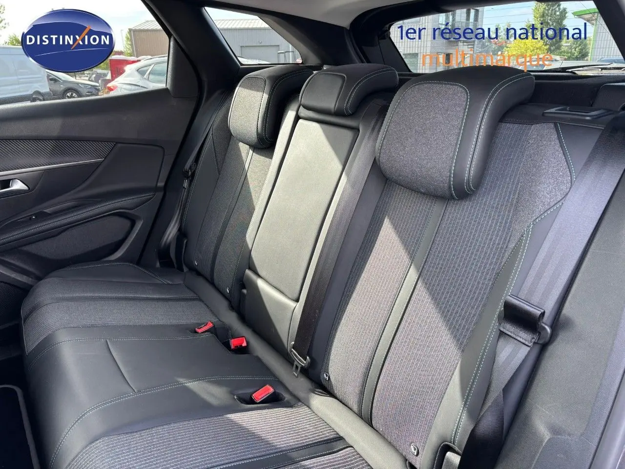 Vue intérieure des sièges arrière du Peugeot 3008 hybride 2022, tissu et cuir noir avec surpiqûres contrastantes.