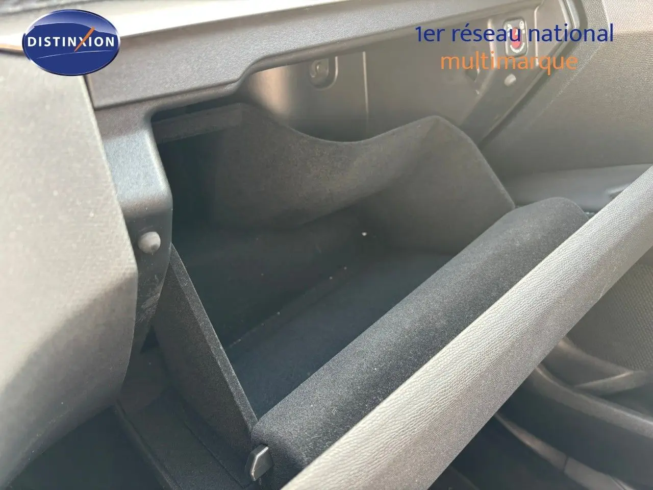 Gros plan sur la boîte à gants ouverte de la Peugeot 3008 1.6 Hybrid 225ch, intérieur noir.