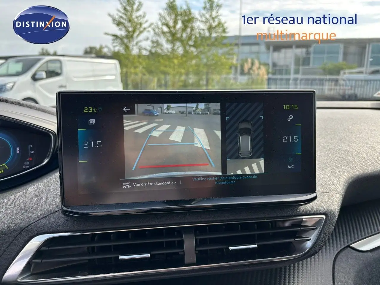 Vue intérieure du tableau de bord du Peugeot 3008 hybride 2022, écran central affichant la caméra de recul et la climatisation.