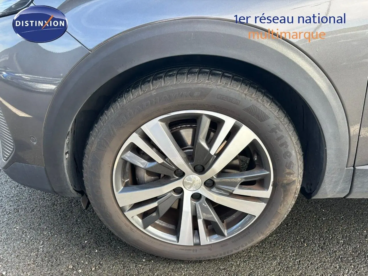 Gros plan sur la roue avant droite d’un Peugeot 3008 gris platinium métal avec jante alliage biton.