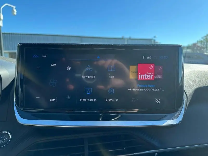 Écran tactile central du tableau de bord du Peugeot 2008 1.2 Hybrid 145ch Allure en bleu, affichant les options de navigation et climatisation.