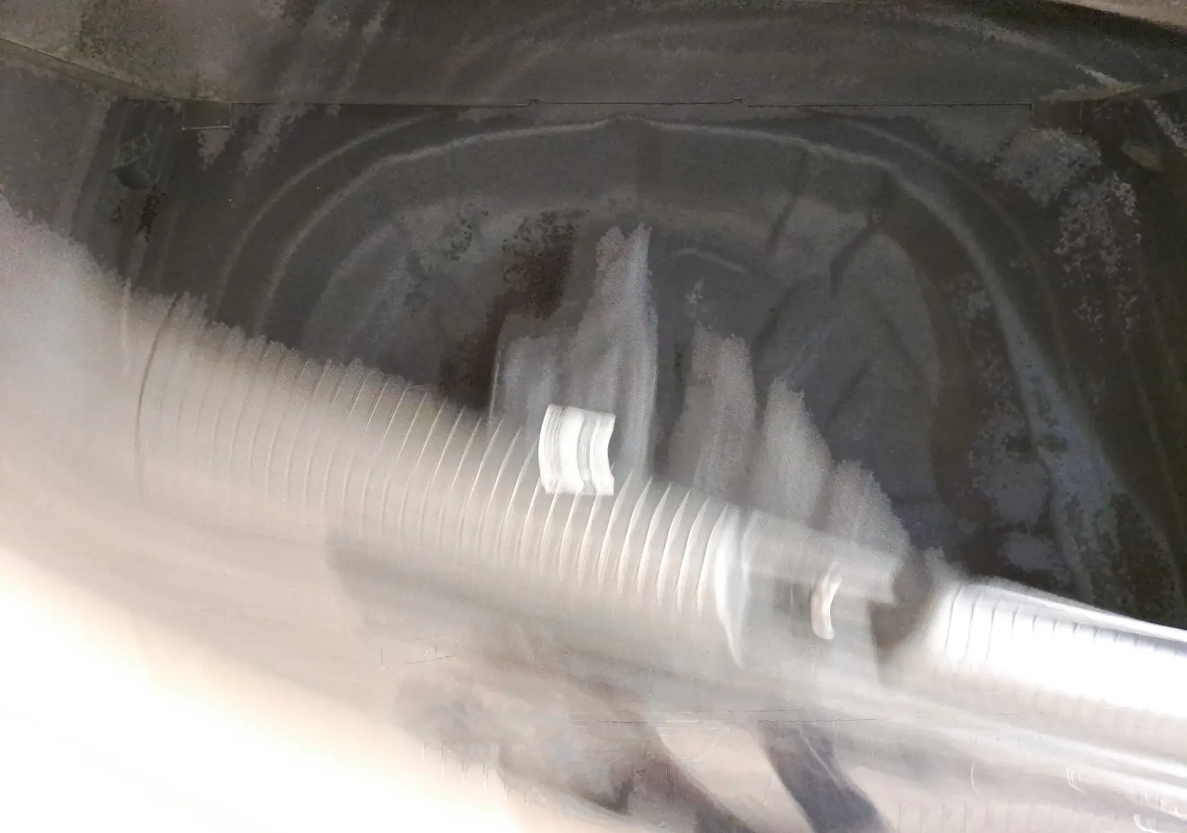 Vue intérieure floue du coffre d'une Volkswagen Golf 1.5 eTSI 150 DSG7 R Line noir intense nacré sans objet visible.