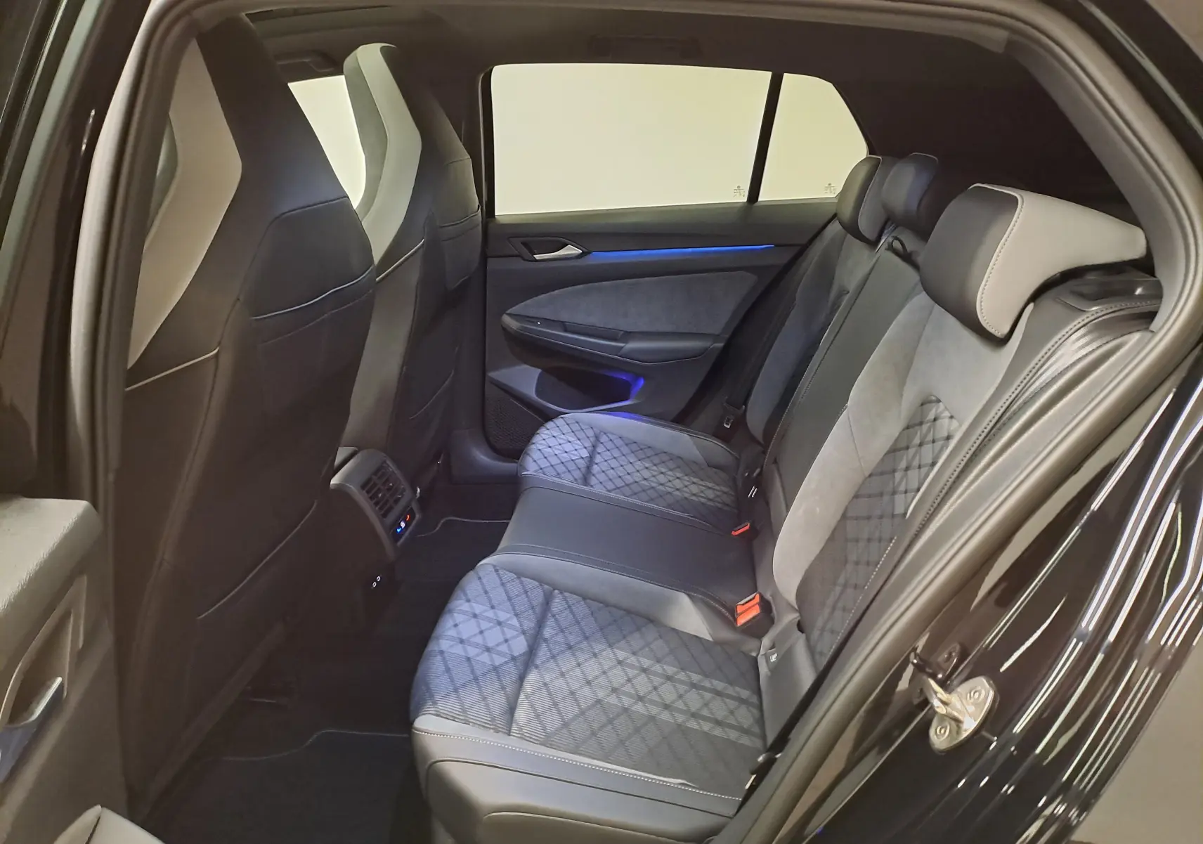 Vue côté droit de l’intérieur arrière noir et gris avec sièges en tissu et cuir sur Volkswagen Golf 2023 R-Line.