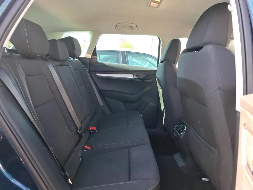 Vue intérieure arrière côté gauche du Skoda Karoq bleu 2026, montrant les sièges arrière noirs et les aérateurs centraux.