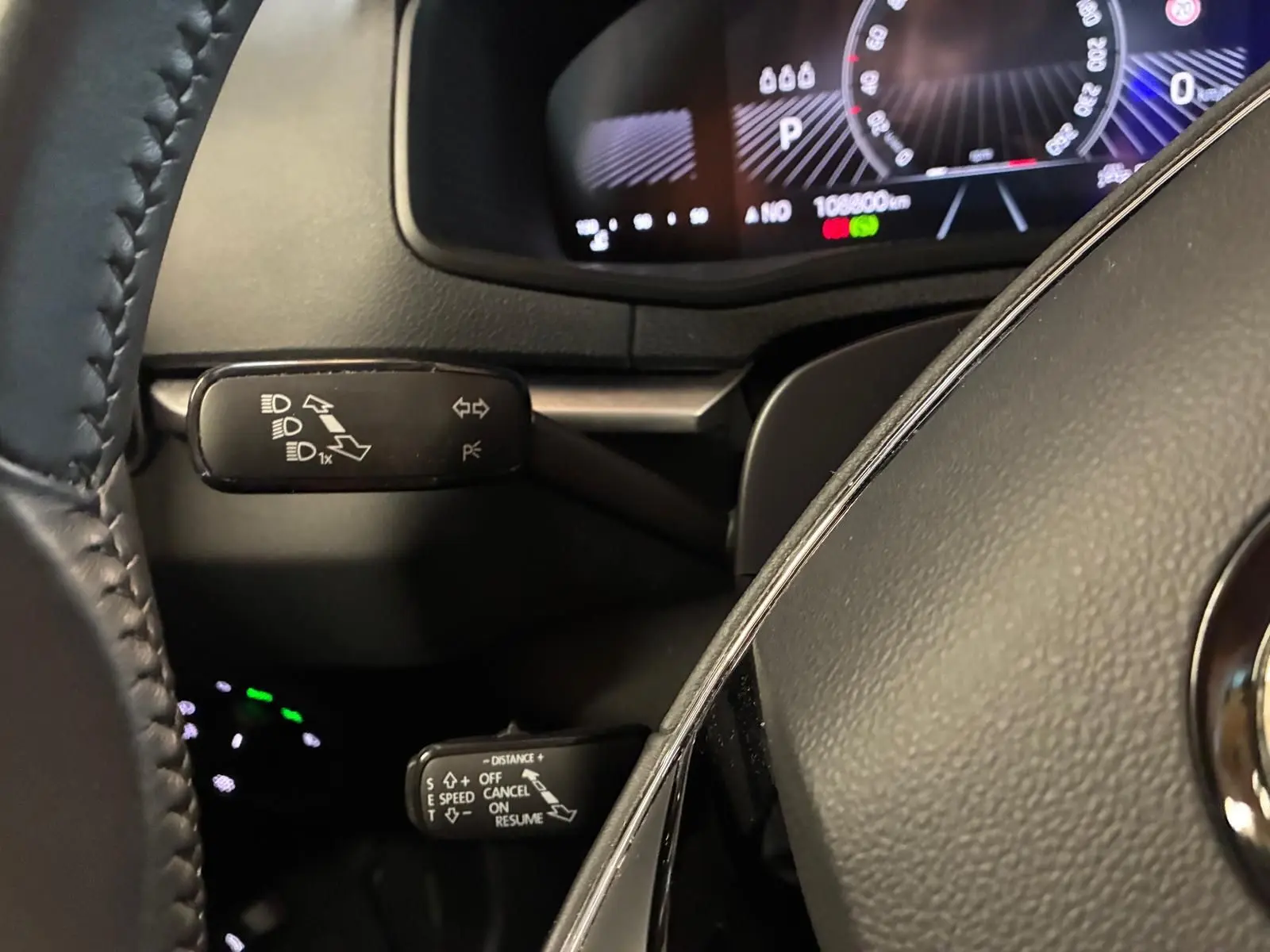 Gros plan sur le volant cuir et les commandes de clignotants et régulateur de vitesse du Skoda Karoq 2023.