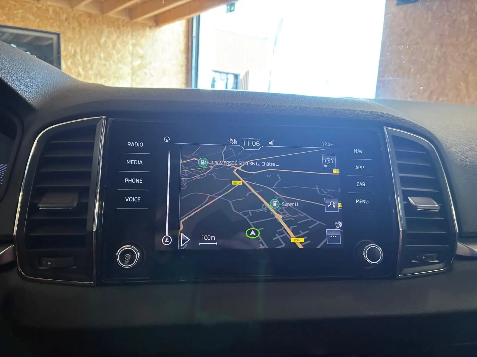 Écran tactile central avec navigation affichée, entouré d'aérateurs noirs dans l'habitacle d'un Skoda Karoq bleu.