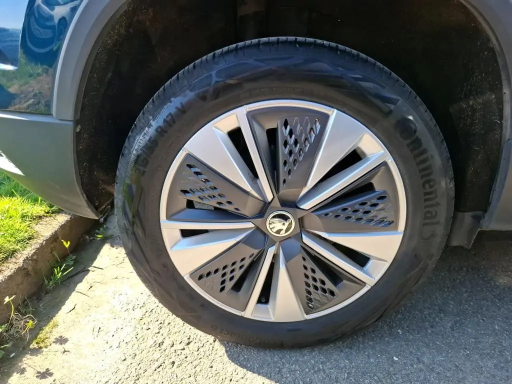 Gros plan sur la jante alu 17'' et le pneu Continental du côté avant droit d'un Skoda Karoq bleu.