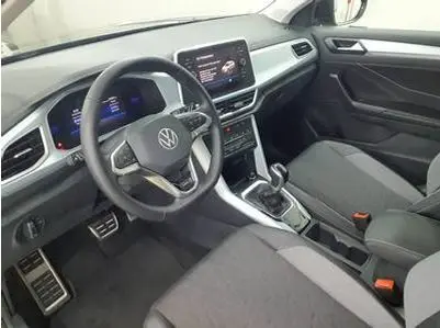 Intérieur du Volkswagen T-Roc 2025 vu côté conducteur, tableau de bord numérique et volant multifonction gris foncé.