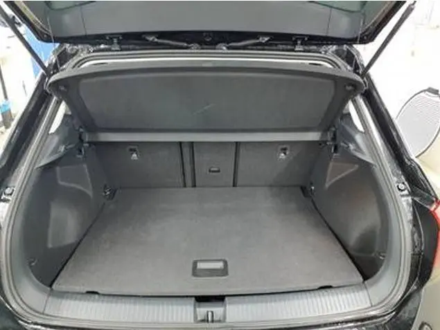 Coffre ouvert vu de l'arrière d'un Volkswagen T-Roc gris foncé 2025, montrant un espace de chargement spacieux et propre.