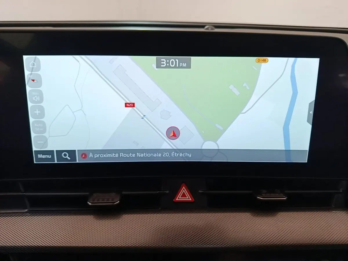 Écran tactile central du tableau de bord du Kia Sportage gris clair, affichant la navigation GPS en plein jour.