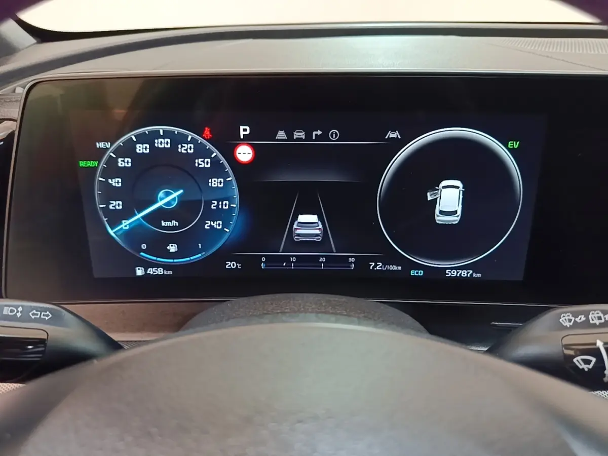 Affichage numérique du tableau de bord du Kia Sportage hybride rechargeable, vue frontale centrée sur le compteur et l'écran multifonctions.
