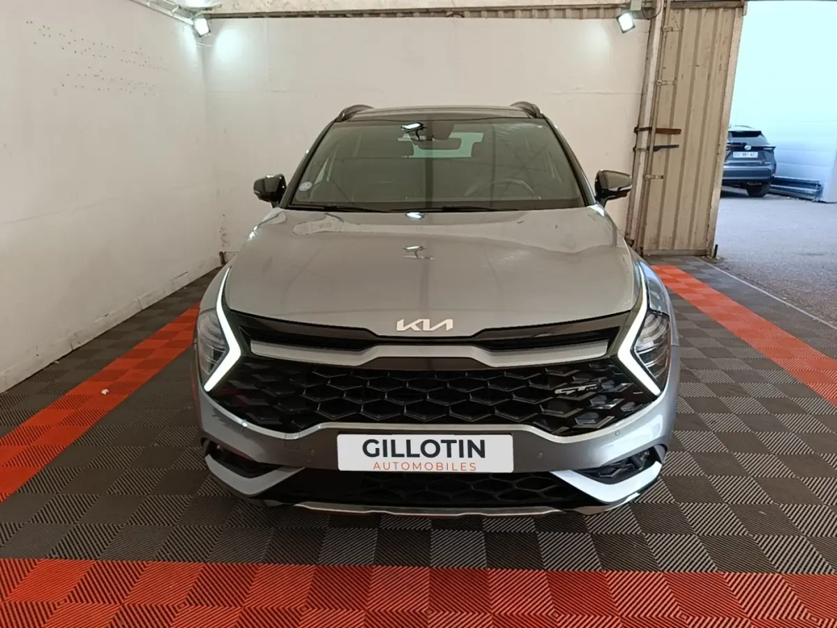 Vue avant d'un KIA Sportage gris clair avec éclairage LED en forme de C et calandre noire hexagonale.
