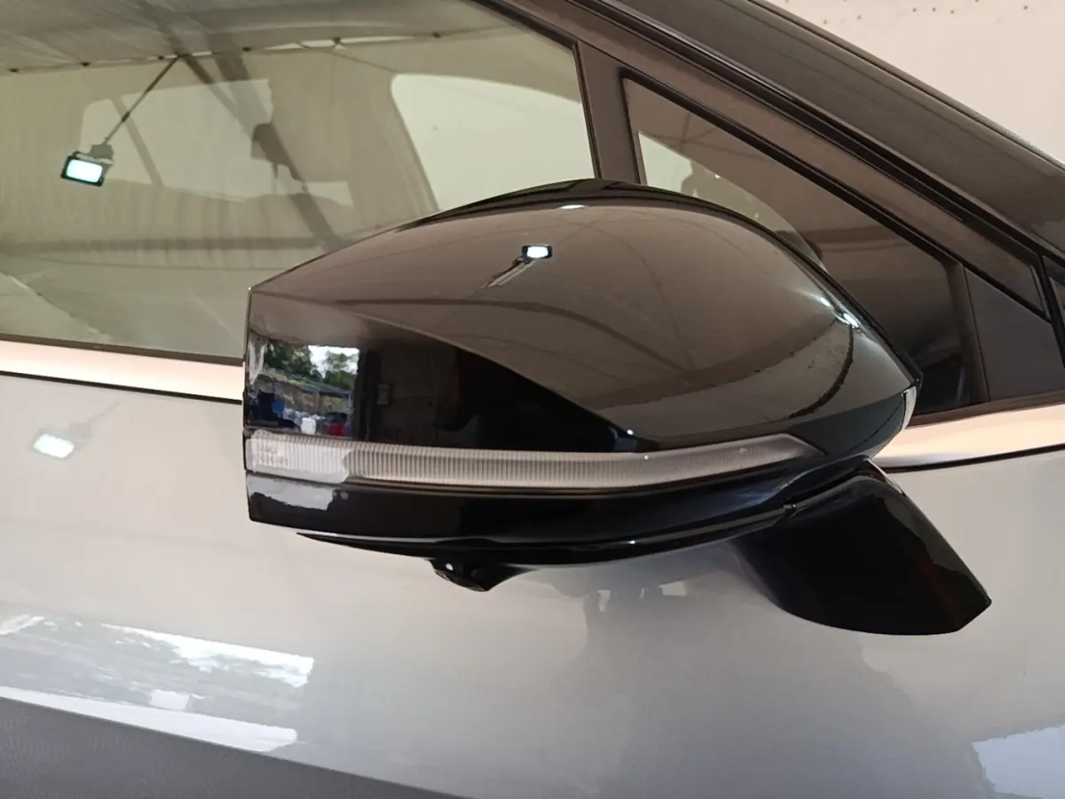 Rétroviseur noir en gros plan sur le côté gauche d’un KIA Sportage gris clair hybride rechargeable 2022.