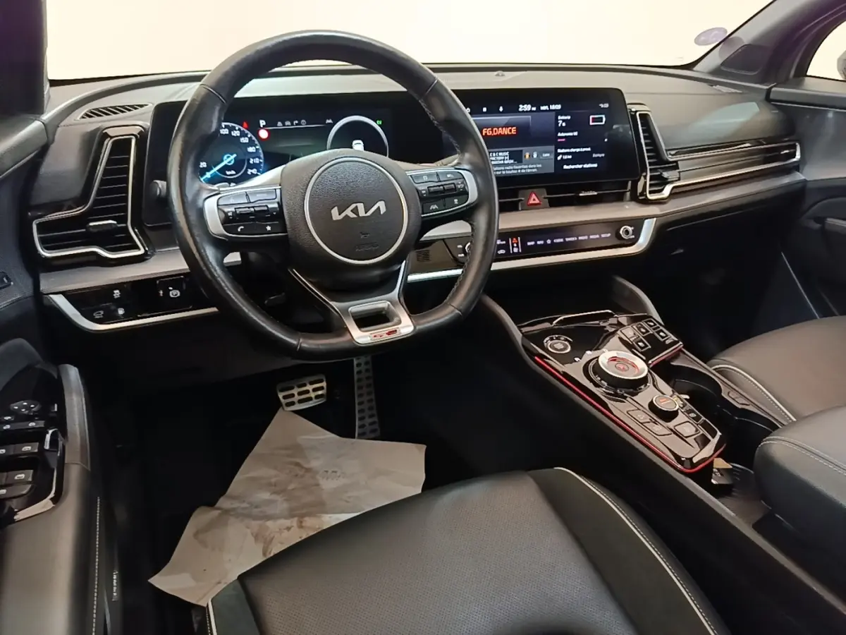 Vue intérieure côté conducteur du tableau de bord noir et volant cuir du KIA Sportage hybride rechargeable 2022.