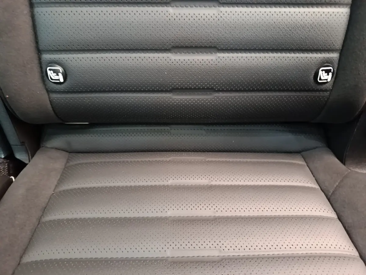 Gros plan sur la banquette arrière en cuir perforé gris foncé du Kia Sportage 2022, avec logos Isofix visibles.