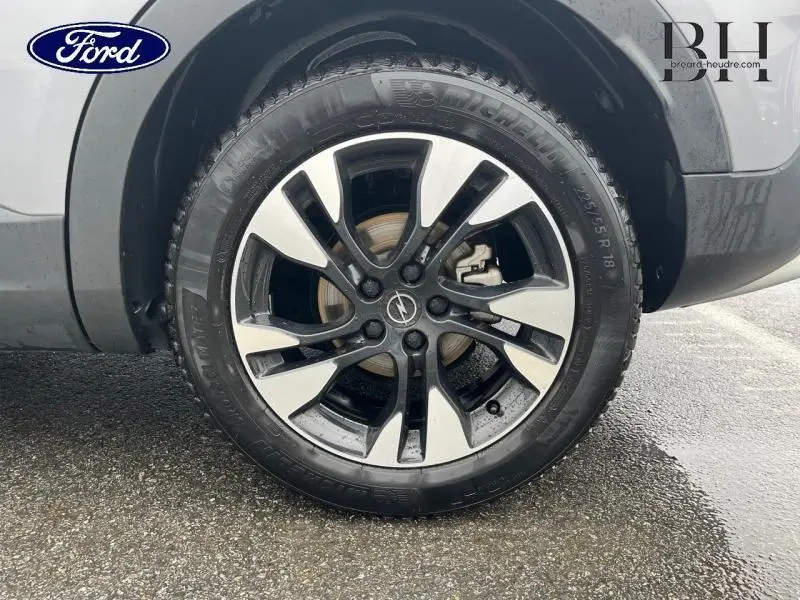 Gros plan sur la roue avant gauche de l'Opel Grandland X 2020 avec jante alu bicolore noir et argent.