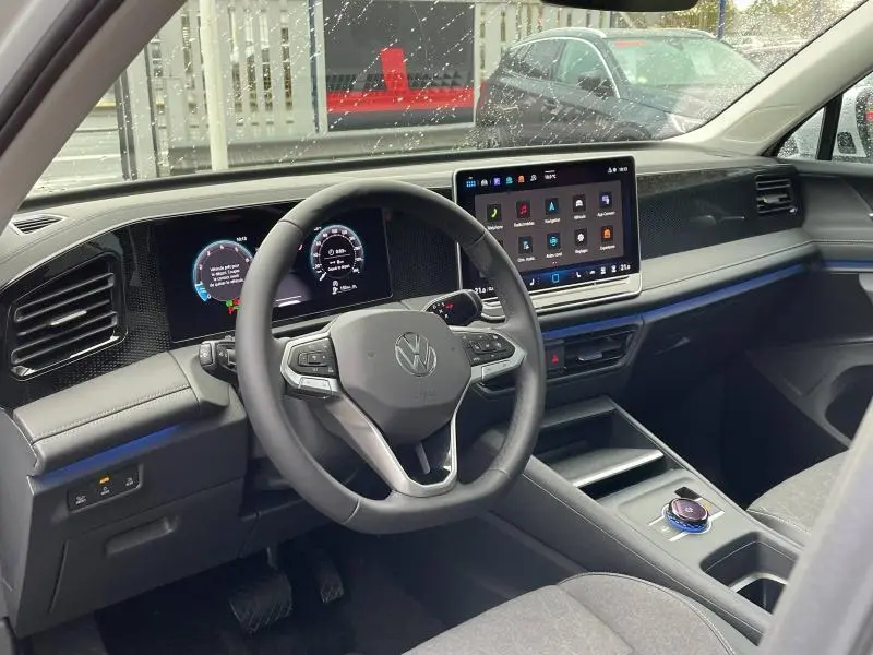 Vue intérieure côté conducteur du Volkswagen Tiguan 2025, tableau de bord moderne avec écran tactile et volant multifonction noir.