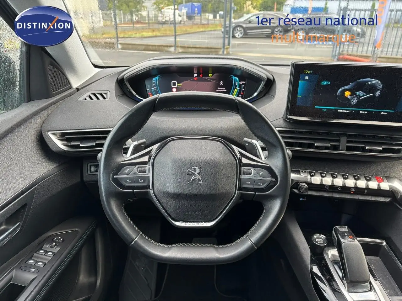 Vue intérieure centrée sur le volant noir du Peugeot 3008 hybride 2022 avec tableau de bord digital et écran tactile.