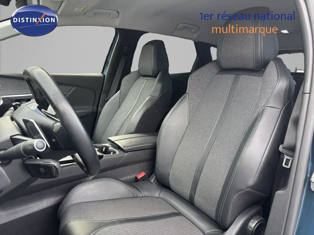 Vue intérieure côté conducteur du Peugeot 3008 hybride 2022, sièges en cuir et tissu gris avec surpiqûres contrastées.
