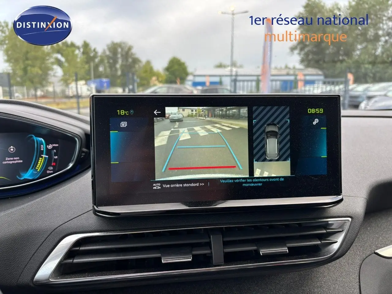 Vue intérieure du tableau de bord du Peugeot 3008 hybride 2022, écran affichant la caméra de recul et les aides au stationnement.