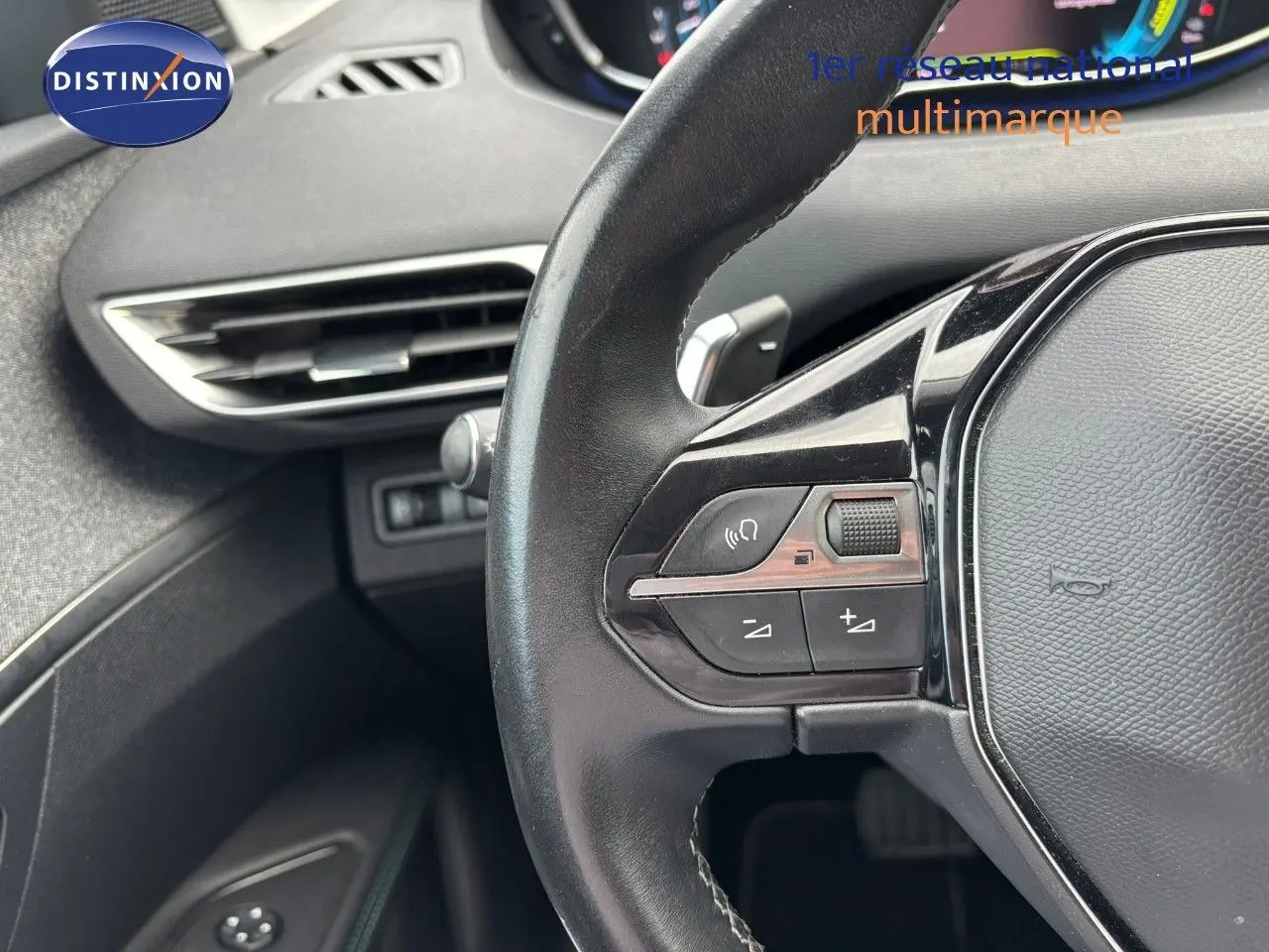 Gros plan sur le volant noir et la partie gauche du tableau de bord du Peugeot 3008 bleu Celebes Hybrid 2022.