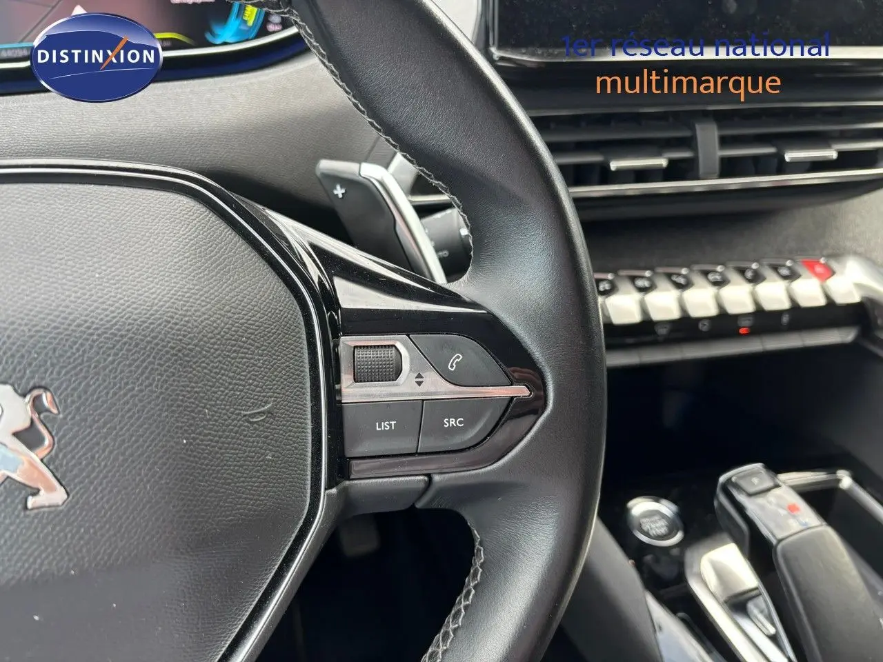 Gros plan sur le volant et la console centrale du Peugeot 3008 hybride, mettant en valeur les commandes intégrées et le levier de vitesse.