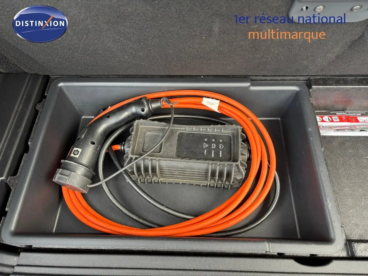 Câble de recharge orange rangé dans le coffre du Peugeot 3008 hybride rechargeable bleu Célèbes Métal.